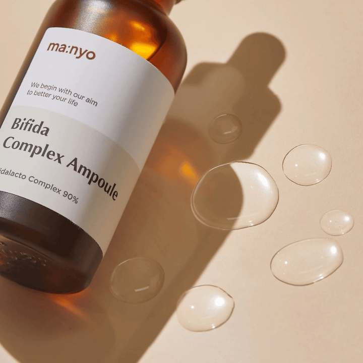 En flaska ma:nyo Bifida Complex Ampoule 50ml på en beige yta.