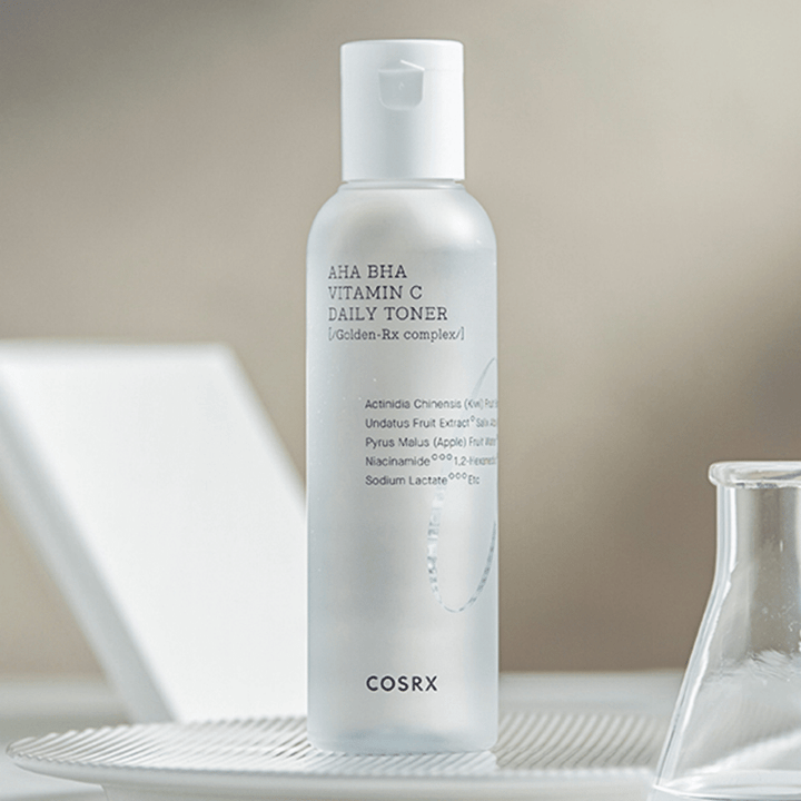 En flaska COSRX Refresh AHA BHA Vitamin C Daily Toner 150ml som sitter ovanpå en vit platta.