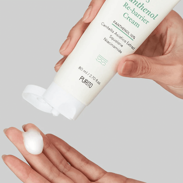 En hand håller i en tub med PURITOs B5 Panthenol Re-Barrier Cream 80ml med hudbarriär och fukt.